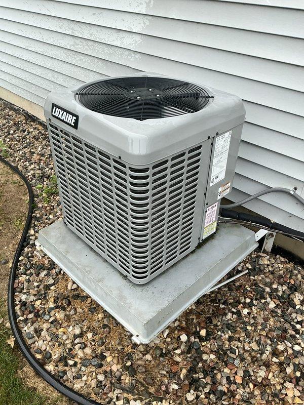 Completed scheduled air conditioning maintenance on Luxaire condensing unit. Performed system inspection, replaced air filter, and cleaned condenser pad. Unit operating within normal parameters with proper airflow through louvers and fan assembly functioning correctly.