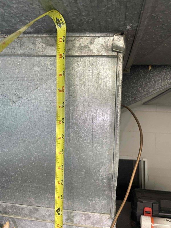 Conducted on-site evaluation of basement-located air conditioning system exceeding 20 years of service life to provide replacement estimate. Unit currently operational but approaching end of expected lifespan. Documented existing ductwork dimensions and configuration, measuring supply plenum at approximately 14 inches vertically and 36 inches horizontally to ensure proper sizing for replacement equipment. Assessed refrigerant line routing, existing electrical connections, and condensate drainage setup. Photographed current installation including metal ductwork, copper refrigerant lines, and system controls to determine compatibility requirements and identify any modifications needed for new equipment installation.