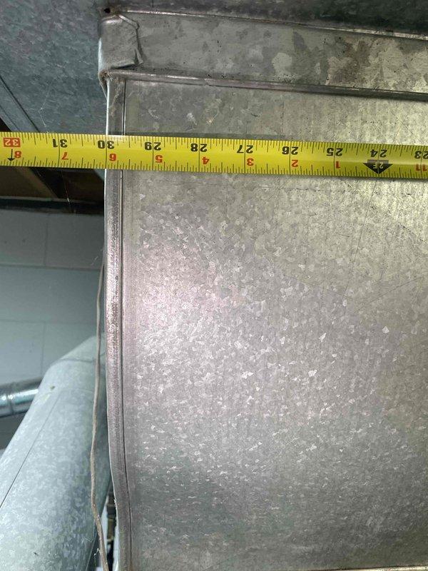 Conducted on-site evaluation of basement-located air conditioning system exceeding 20 years of service life to provide replacement estimate. Unit currently operational but approaching end of expected lifespan. Documented existing ductwork dimensions and configuration, measuring supply plenum at approximately 14 inches vertically and 36 inches horizontally to ensure proper sizing for replacement equipment. Assessed refrigerant line routing, existing electrical connections, and condensate drainage setup. Photographed current installation including metal ductwork, copper refrigerant lines, and system controls to determine compatibility requirements and identify any modifications needed for new equipment installation.