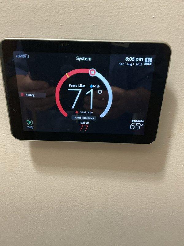 Completed comprehensive furnace tune-up and safety inspection on 5-year-old unit located in basement. Inspection included thorough evaluation of heating system, humidifier, Lennox digital thermostat (confirmed operational at 71°F with heat set to 77°F), and hot water tank. Notable findings included rust-colored corrosion on furnace base pan indicating previous moisture intrusion or condensate drainage issues; control board and electrical connections inspected and found functioning properly with all wire terminations secure.