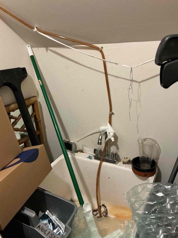 Responded to service call for condensate pump running continuously with no water discharge. Upon inspection, found the blue condensate pump at base of air handler was cycling but not pumping water through drain line to sink. Diagnosed blockage in discharge tubing and cleared obstruction, restoring proper condensate drainage. Verified pump operation and confirmed system returned to normal function with condensate flowing correctly through drain line.
