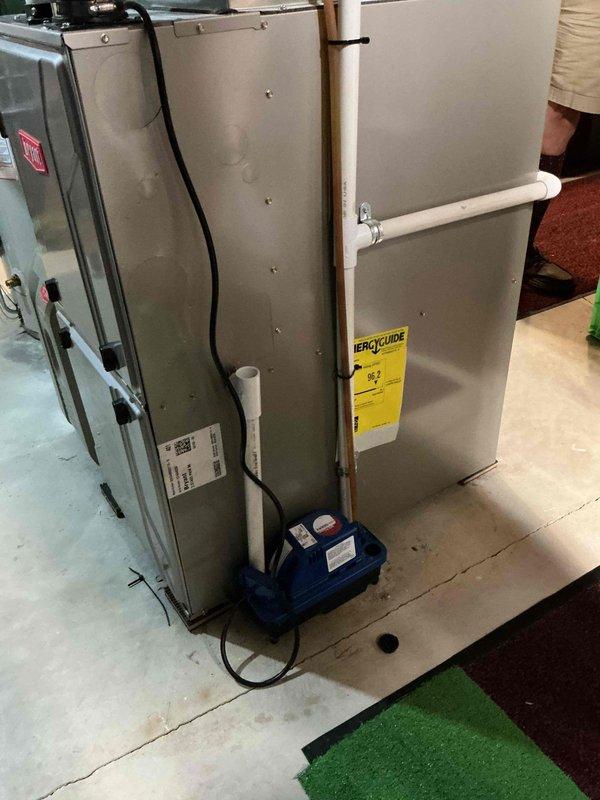 Responded to service call for condensate pump running continuously with no water discharge. Upon inspection, found the blue condensate pump at base of air handler was cycling but not pumping water through drain line to sink. Diagnosed blockage in discharge tubing and cleared obstruction, restoring proper condensate drainage. Verified pump operation and confirmed system returned to normal function with condensate flowing correctly through drain line.