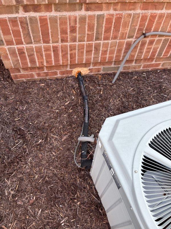 Provided estimate for replacement of 22+ year old non-operational commercial ground-level air conditioning unit located at rear of building. Existing system positioned on mulch bed adjacent to brick wall with refrigerant lines and electrical conduit running to building connection point. Assessed site conditions, documented equipment specifications, and prepared replacement proposal for new AC system with natural gas furnace compatibility.