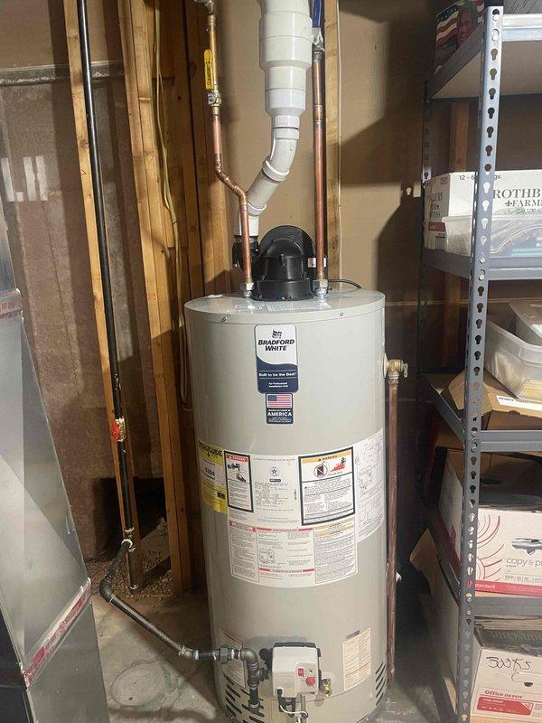 Completed full HVAC system installation in residential basement including 70,000 BTU Lennox furnace with sheet metal plenum and white PVC venting system, 2.5-ton air conditioning unit with evaporator coil configured for rear discharge, and Bradford White 50-gallon gas water heater model RG1PV50S6N. All units installed per manufacturer specifications with proper venting, gas connections, condensate drainage, and electrical reconnections. System tested and verified operational upon completion.