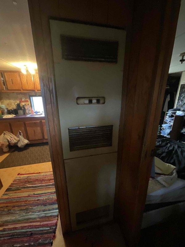 Responded to service call for furnace not staying lit. Upon inspection, found 10+ year old HVAC system with furnace located in utility area and outdoor condensing unit showing significant age and weathering. Evaluated both indoor and outdoor components, documented existing equipment condition, and provided comprehensive estimate for full system replacement due to age and operational issues affecting furnace ignition reliability.