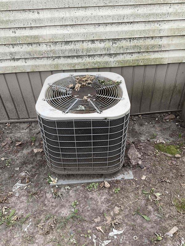 Responded to service call for furnace not staying lit. Upon inspection, found 10+ year old HVAC system with furnace located in utility area and outdoor condensing unit showing significant age and weathering. Evaluated both indoor and outdoor components, documented existing equipment condition, and provided comprehensive estimate for full system replacement due to age and operational issues affecting furnace ignition reliability.