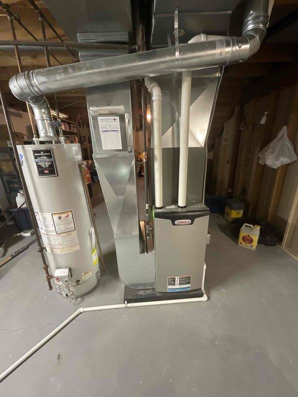 Completed HVAC equipment assessment for replacement estimate on non-operational 6-year-old Lennox furnace and air conditioning system in basement installation. Natural gas furnace located in unfinished basement utility area with existing ductwork and venting infrastructure. Evaluated current Lennox outdoor condenser unit positioned on exterior of home with electrical disconnect and proper clearances. Documented existing equipment configuration including galvanized steel ductwork, PVC condensate drainage, and electrical connections to provide comprehensive replacement options for both heating and cooling systems.