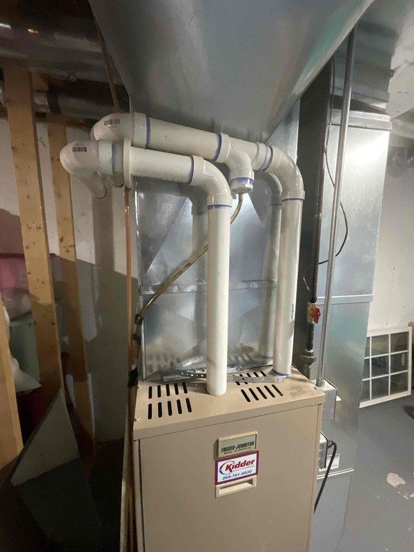 Completed on-site evaluation of 25-year-old residential HVAC system for full replacement estimate. Inspected existing furnace unit in basement utility area, noting current PVC venting configuration, ductwork connections, and overall system layout. Documented existing equipment specifications, air distribution infrastructure, and installation environment to provide accurate replacement recommendations for both heating and cooling components scheduled for fall installation.