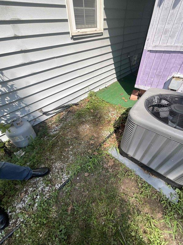 Provided estimate for air conditioning system replacement at residential property. Current 5-year-old outdoor condenser unit, located on concrete pad in side yard between buildings, is non-operational and requires full replacement. Indoor air handling equipment is positioned in basement and will be included in replacement scope.