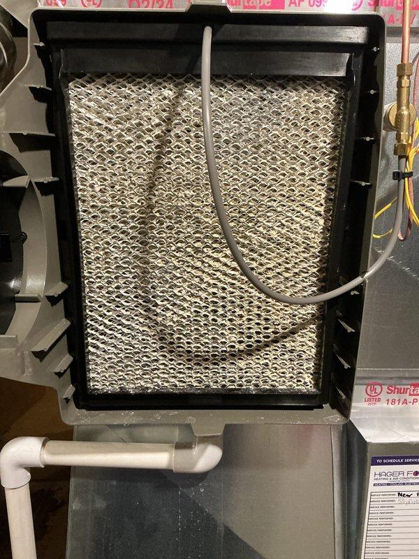 Completed routine air conditioning maintenance on a four-year-old system with no reported issues. Performed comprehensive AC tune-up including inspection of the indoor evaporator coil and air handler unit, which showed normal operational wear with some dust and mineral deposit accumulation on the coil surface. Verified blower motor assembly operation, checked refrigerant lines and brass fittings for proper connection and integrity, and inspected condensate drain line routing. Evaluated outdoor condenser unit positioned on pad adjacent to building exterior, confirming proper airflow through horizontal louvers and verifying fan operation. Checked electrical connections and conduit entry point at building wall. System operating within normal parameters with no deficiencies noted requiring immediate attention. Unit continues to provide adequate cooling performance as designed.