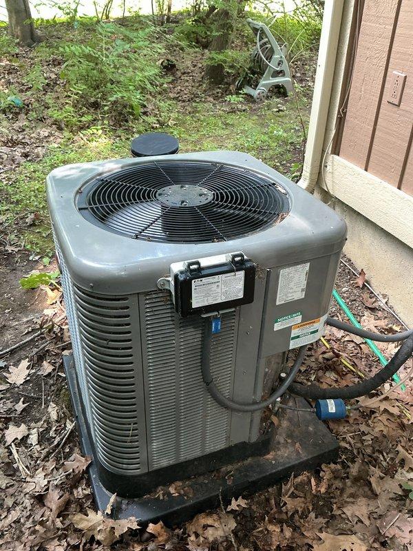 Completed routine air conditioning maintenance on a four-year-old system with no reported issues. Performed comprehensive AC tune-up including inspection of the indoor evaporator coil and air handler unit, which showed normal operational wear with some dust and mineral deposit accumulation on the coil surface. Verified blower motor assembly operation, checked refrigerant lines and brass fittings for proper connection and integrity, and inspected condensate drain line routing. Evaluated outdoor condenser unit positioned on pad adjacent to building exterior, confirming proper airflow through horizontal louvers and verifying fan operation. Checked electrical connections and conduit entry point at building wall. System operating within normal parameters with no deficiencies noted requiring immediate attention. Unit continues to provide adequate cooling performance as designed.