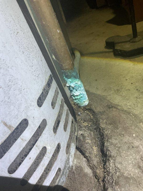 Responded to no hot water complaint on tanked water heater that was improperly installed by previous contractor and has experienced ongoing operational issues since original installation. Upon inspection, discovered severe corrosion on copper piping connections at base of unit, with visible turquoise oxidation on supply lines and heavy rust accumulation at pipe fittings. Evidence of chronic moisture exposure and water leakage observed on concrete floor beneath unit, with significant staining and discoloration present. Documented all corroded components and compromised connections for repair recommendations.