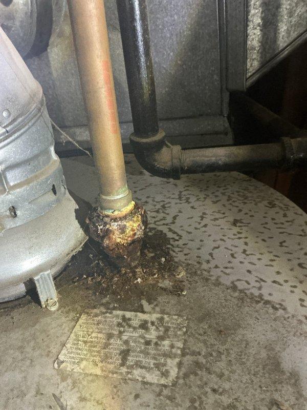 Responded to no hot water complaint on tanked water heater that was improperly installed by previous contractor and has experienced ongoing operational issues since original installation. Upon inspection, discovered severe corrosion on copper piping connections at base of unit, with visible turquoise oxidation on supply lines and heavy rust accumulation at pipe fittings. Evidence of chronic moisture exposure and water leakage observed on concrete floor beneath unit, with significant staining and discoloration present. Documented all corroded components and compromised connections for repair recommendations.