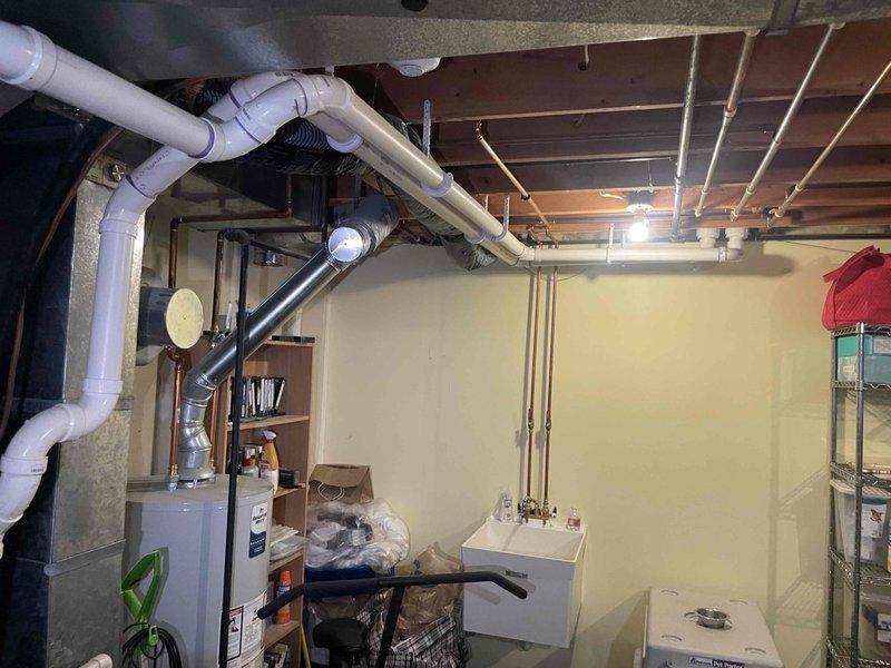 Provided replacement estimate for 30-year-old air conditioning unit located in basement with non-functional fan motor. Assessed existing equipment dimensions and configuration in utility space alongside natural gas furnace, documented current system layout including ductwork and plumbing routing for replacement planning.
