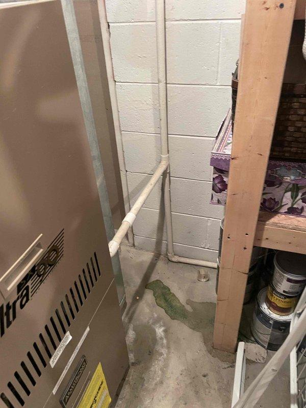 Provided comprehensive estimate for replacement of non-operational air conditioning system originally installed in 1995, located in basement utility room. Assessed existing HVAC equipment configuration, including furnace setup, ductwork measurements, and condensate drainage system with PVC piping. Documented equipment specifications, spatial constraints, and moisture conditions on concrete floor to determine appropriate replacement unit sizing and installation requirements.