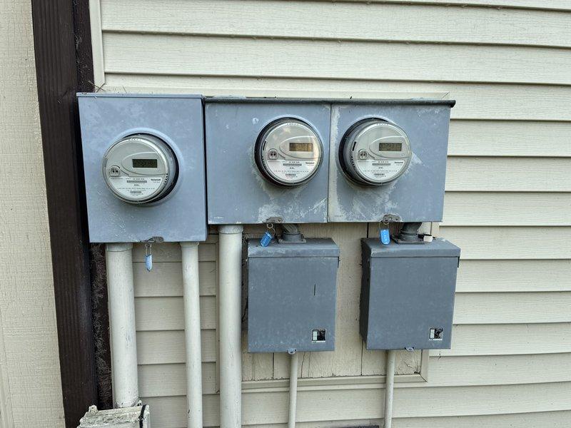 Conducted comprehensive site evaluation for whole home generator installation at residential property with shared driveway access. Assessed existing electrical service configuration consisting of three digital utility meters with associated disconnect panels and conduit runs on exterior wall. Evaluated current outdoor mechanical equipment placement and utility corridor to determine optimal generator positioning, load requirements, and integration with multi-meter electrical system. Documented site conditions including available mounting surfaces, clearance requirements, fuel supply routing options, and necessary electrical connections to support automatic transfer switch installation and generator tie-in to existing service panels.