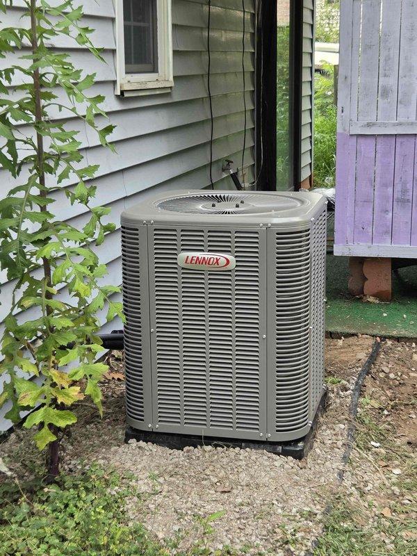 Completed installation of 2-ton Lennox air conditioning condenser unit and evaporator coil at residential property. Unit positioned on pad against rear exterior wall with proper clearances maintained, refrigerant lines connected and insulated, electrical disconnect installed, and all connections tested for leaks. System commissioned, charged to manufacturer specifications, and verified operational with proper airflow and temperature differential across coil.