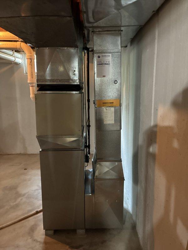 Provided replacement estimate for 30-year-old original air conditioning system and natural gas furnace located in basement. Inspected existing beige-colored furnace unit with connected ductwork and plenum system, documented current equipment configuration including flexible duct connections and galvanized steel ductwork. Current system operational at time of assessment.
