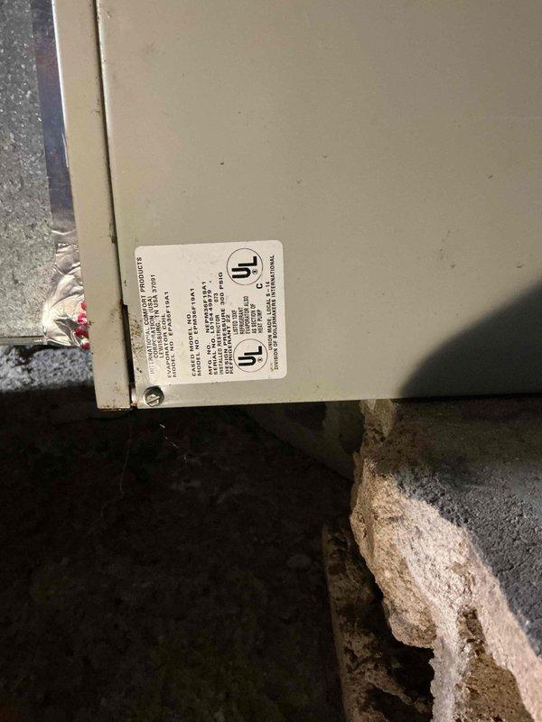 Responded to no cooling call at residential property. Upon arrival, found outdoor condensing unit installed on concrete pad with rock landscaping against exterior wall. Performed diagnostic evaluation of system with unknown service history. Inspected condenser unit exterior components and verified initial complaint of non-operational condenser fan motor. Documented equipment nameplate data and unit condition through photographic records. Reviewed system specifications and electrical connections at outdoor unit. Identified condenser fan motor failure as primary cause of no cooling condition affecting entire home. Provided customer with diagnostic findings and repair recommendations to restore system operation.