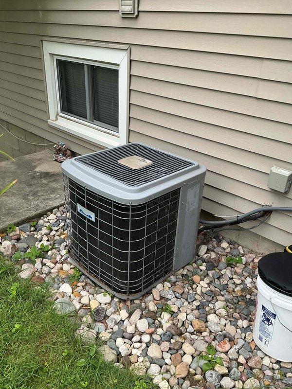 Responded to no cooling call at residential property. Upon arrival, found outdoor condensing unit installed on concrete pad with rock landscaping against exterior wall. Performed diagnostic evaluation of system with unknown service history. Inspected condenser unit exterior components and verified initial complaint of non-operational condenser fan motor. Documented equipment nameplate data and unit condition through photographic records. Reviewed system specifications and electrical connections at outdoor unit. Identified condenser fan motor failure as primary cause of no cooling condition affecting entire home. Provided customer with diagnostic findings and repair recommendations to restore system operation.