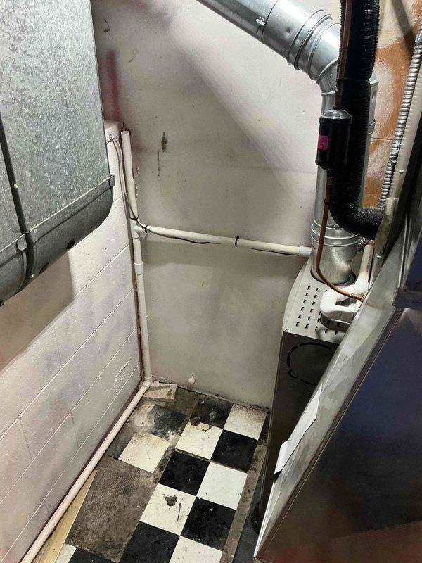Responded to service call for water leaking from forced air furnace, a recurring seasonal issue from previous year. Upon inspection, examined the HVAC system including ductwork configuration and furnace cabinet installation. System was operational and maintaining heating capability at time of service. Documented equipment condition and ductwork layout with photographs for service records. Assessed potential condensate drainage concerns related to seasonal temperature changes affecting the unit.
