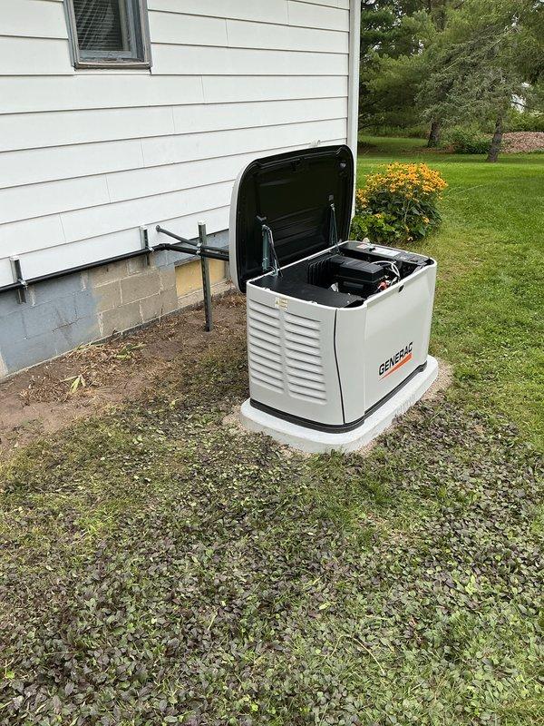 Completed installation of 18kW Generac residential backup generator system on concrete pad adjacent to home exterior. Installation included gas line connection with pressure testing, transfer switch integration with existing 200-amp electrical service, battery installation with proper terminal connections, and conduit runs from main panel to generator unit. All mechanical and electrical permits obtained and work performed to code specifications.