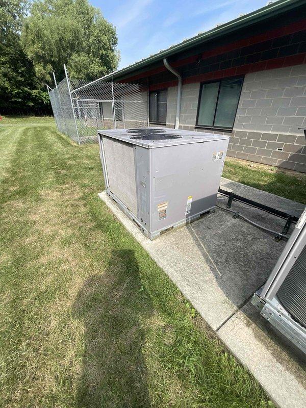 Conducted comprehensive site assessment of commercial HVAC system for complete equipment replacement. Evaluated four existing air conditioning units and four furnaces currently in service, documenting equipment conditions and placement locations. Inspected 5-ton condenser unit positioned in overgrown vegetation area and additional outdoor units on concrete pads adjacent to building structures. Assessment identified need for full system replacement to address aging equipment and operational concerns. Provided detailed replacement estimate for complete HVAC system upgrade including all condenser units and heating equipment.