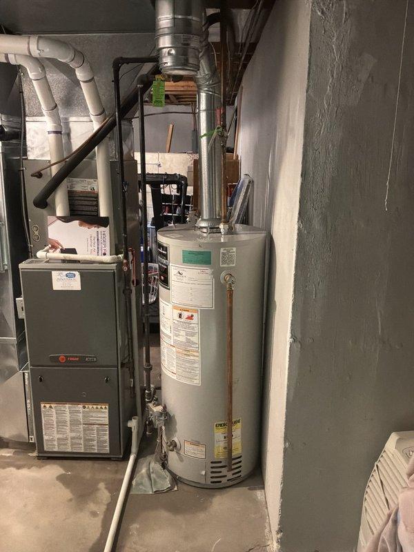 Responded to service call for malfunctioning residential water heater experiencing loss of hot water production and active leaking. Performed on-site assessment of existing tank-style water heater in basement mechanical room, documented current equipment condition and configuration including venting system, copper supply lines, and surrounding HVAC infrastructure. Provided estimate for complete water heater replacement with new tank-style unit to restore hot water service and eliminate leak hazard.