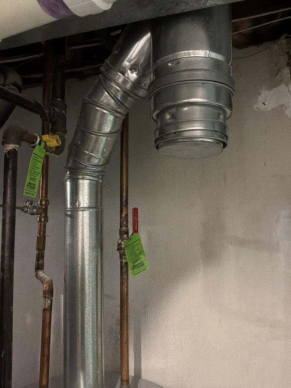 Responded to service call for malfunctioning residential water heater experiencing loss of hot water production and active leaking. Performed on-site assessment of existing tank-style water heater in basement mechanical room, documented current equipment condition and configuration including venting system, copper supply lines, and surrounding HVAC infrastructure. Provided estimate for complete water heater replacement with new tank-style unit to restore hot water service and eliminate leak hazard.