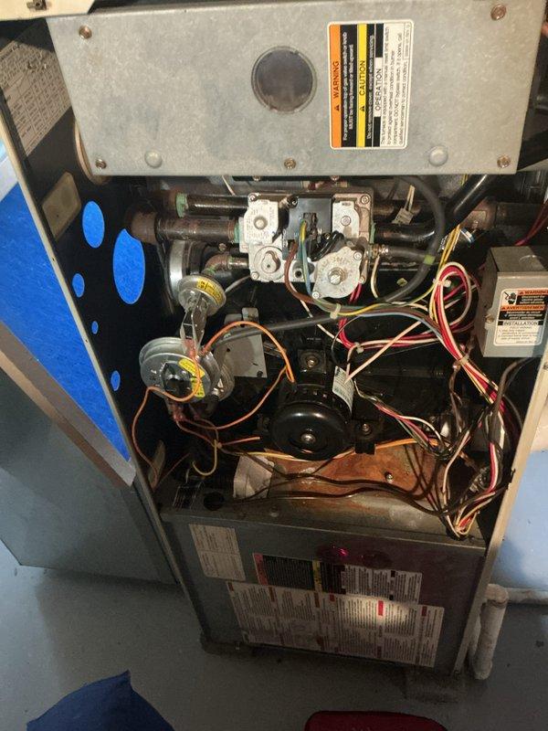Responded to service call for water leaking from furnace during air conditioning operation. Diagnosed leak originating from 1-inch PVC condensate drain pipe at seal joint approximately halfway up where pipe transitions to downward elbow. Inspected heating system components, accessed interior compartment, and performed diagnostic testing with digital multimeter to verify system operation. Identified failed seal at PVC pipe connection as source of water intrusion. Discussed maintenance service options for furnace with property owner for consideration.