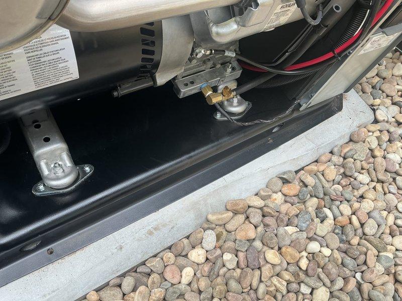Responded to warranty callback for oil leak on recently installed Kohler 20RCA standby generator. Upon arrival, inspected generator unit with top access panel open and examined internal components including engine block, muffler assembly, coolant reservoir, and battery connections. Conducted thorough diagnostic inspection of all fluid systems, checking oil levels, connections, and potential leak points throughout the engine compartment and undercarriage mounting area. Verified proper installation of all mechanical components, fuel lines, and electrical connections. Documented generator condition with photographs showing internal components and underside mounting assembly. Unit operational at time of inspection, no active leaking observed during callback visit.