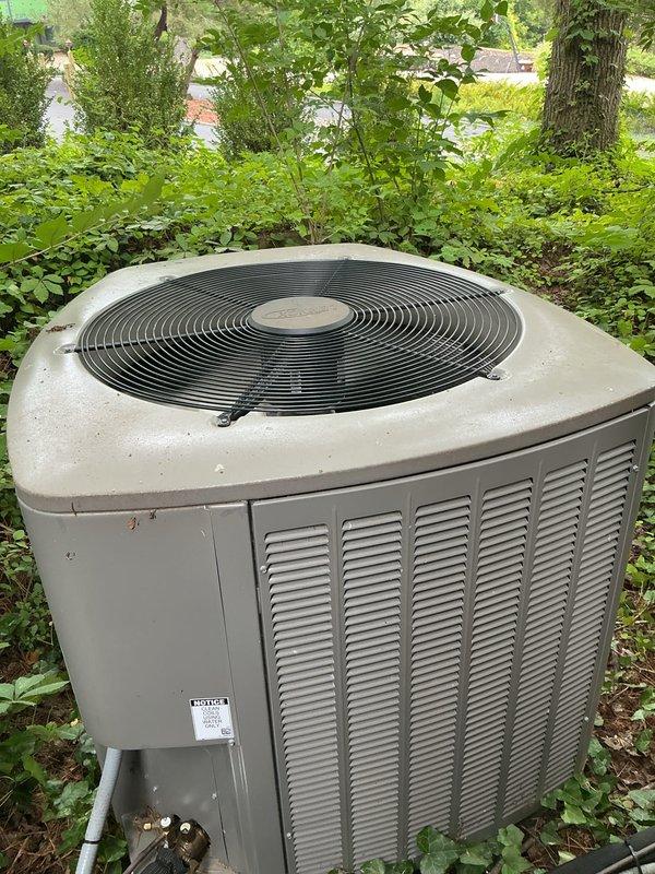 Completed annual preventative maintenance on residential split system air conditioning unit. Performed comprehensive inspection of outdoor condenser unit including visual assessment of cabinet condition, fan motor operation, and refrigerant line connections. Unit found operating within normal parameters with no immediate service concerns identified. Condenser positioned on hillside location with adequate clearance, though surrounding vegetation noted for monitoring. All components functioning properly at time of service.