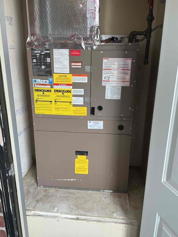 Performed diagnostic evaluation on 16-year-old National Comfort Products central air conditioning system (Model CRP030S1-BD) with factory refrigerant charge of 4.30 lbs in recently purchased condo. Customer reported marginal cooling performance upon taking ownership of property. Conducted visual inspection of indoor air handler unit and evaporator coil assembly, noting reflective insulation wrapping and refrigerant line connections. Examined manufacturer specifications and system ratings displayed on unit labels. Documented system configuration including compressor specifications, indoor blower motor, and outdoor fan motor ratings. Photographed unit installation in utility closet showing proper positioning and existing condition of equipment. System remains operational with heating and cooling capability intact. Provided assessment findings and discussed options for maintenance service versus system replacement given age of equipment and current performance concerns.