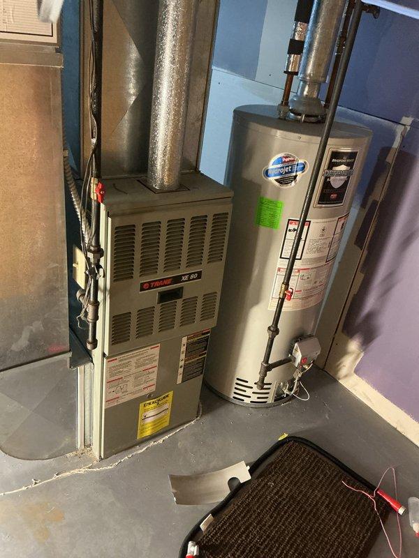 Responded to no cooling complaint on Trane XE 1000 air conditioning system. Upon arrival, verified outdoor condenser unit was receiving power and compressor was attempting to operate. Performed diagnostic evaluation of refrigerant system and discovered unit was operating with critically low refrigerant charge. Conducted leak detection inspection on refrigerant lines, coil connections, and condenser components. Located active refrigerant leak at service valve connection point on outdoor unit. Recovered remaining refrigerant from system per EPA regulations. Repaired leak at service valve, performed vacuum test to verify system integrity, and recharged system to manufacturer specifications. Verified proper amperage draw on compressor and condenser fan motor. Confirmed adequate airflow through condenser coil and checked temperature split across evaporator coil at indoor air handler. System restored to normal cooling operation with proper superheat and subcooling readings. Advised monitorin