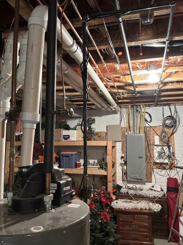Provided comprehensive estimate for replacement of existing 2004 furnace and air conditioning system located in basement. Current natural gas furnace and AC unit are operational but nearing end of service life at approximately 20 years old. Evaluated existing ductwork configuration, electrical connections, and available space for new equipment installation, documenting current system layout including water heater proximity and overhead duct routing to ensure proper sizing and compatibility for replacement units.
