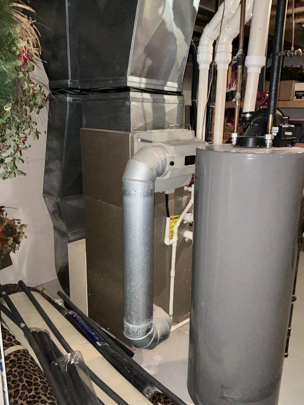 Provided comprehensive estimate for replacement of existing 2004 furnace and air conditioning system located in basement. Current natural gas furnace and AC unit are operational but nearing end of service life at approximately 20 years old. Evaluated existing ductwork configuration, electrical connections, and available space for new equipment installation, documenting current system layout including water heater proximity and overhead duct routing to ensure proper sizing and compatibility for replacement units.