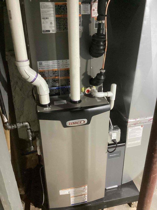 Completed full HVAC system installation including a Lennox 70,000 BTU furnace and 2.5-ton air conditioning unit with evaporator coil. Installed furnace in basement utility space with proper venting using white PVC intake and exhaust piping, mounted refrigerant lines with filter-driers and accumulator components, and established all electrical connections including disconnect switch. Positioned outdoor condensing unit in left side yard and completed refrigerant line connections between indoor and outdoor equipment. All components properly secured, labeled, and reconnected to existing ductwork and electrical systems per manufacturer specifications and mechanical permit requirements.