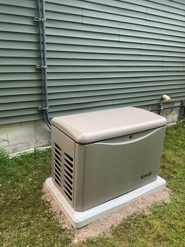 Successfully completed installation of a Kohler 20kW standby generator system at residential property. Installed generator unit on concrete pad with proper mounting and positioning adjacent to building exterior. Ran electrical conduit from generator to transfer switch mounted on exterior wall near existing 200-amp service and electric meter. Made all necessary electrical connections between generator, transfer switch, and main service panel using metallic and PVC conduit as required by code. Secured all conduit runs to building structure with appropriate clamps and supports. Installation performed in accordance with mechanical and electrical permits for generator, gas piping, and 200-amp service. Verified proper clearances, ventilation, and accessibility for maintenance. System tested and confirmed operational upon completion.