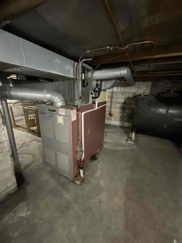 Conducted on-site evaluation for whole-house HVAC system replacement, specifically assessing 19-year-old air conditioning unit and existing oil-fired heating system. Upon inspection of basement mechanical room, determined that requested air conditioning replacement could not proceed due to incompatibility between proposed 454B refrigerant system and existing oil furnace configuration. Documented current equipment setup including metallic air handler with overhead ductwork connections, oil furnace with associated silver-gray insulated ductwork, and supporting mechanical infrastructure. Customer declined heating system replacement at this time, opting to pursue air conditioning upgrade only, which cannot be completed without addressing furnace compatibility issues.