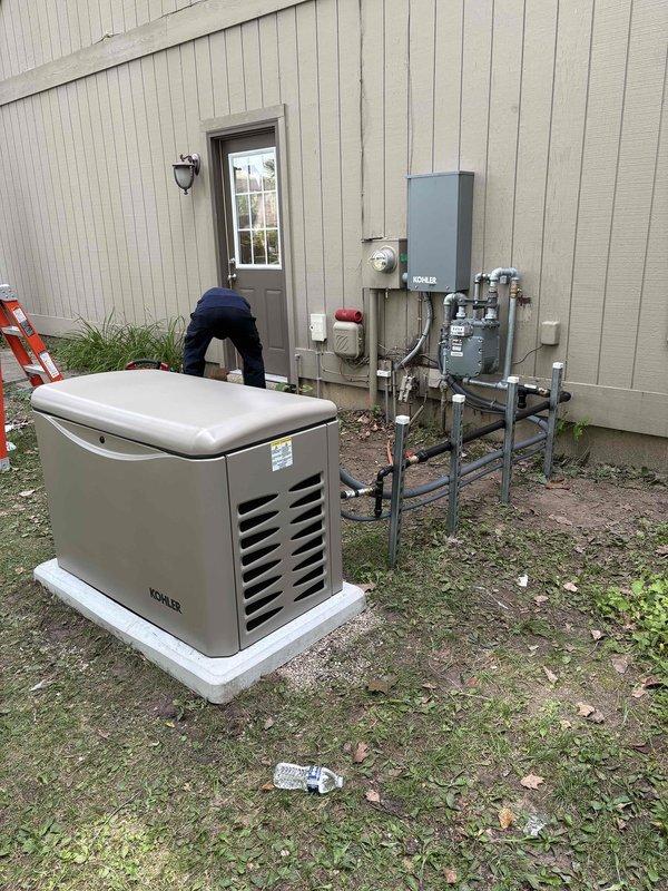 Completed installation of Kohler 26RCA residential standby generator with RXT-JFNC-200ASE automatic transfer switch on prepared concrete pad. Coordinated utility disconnect and reconnect service with power company for safe installation window. Installed 200-amp electrical service upgrade including new meter base, disconnect box, and associated conduit runs mounted to building exterior. Ran gas pipe from existing utility connection to generator location with proper shutoff valves and fittings. Completed all electrical connections from transfer switch to main service panel and generator unit. Installed exterior disconnect and weatherproof enclosures per code requirements. All work performed under valid electrical and mechanical permits with inspection scheduled. System tested and operational upon completion of utility reconnection.