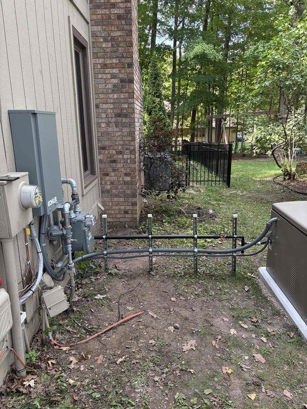 Completed installation of Kohler 26RCA residential standby generator with RXT-JFNC-200ASE automatic transfer switch on prepared concrete pad. Coordinated utility disconnect and reconnect service with power company for safe installation window. Installed 200-amp electrical service upgrade including new meter base, disconnect box, and associated conduit runs mounted to building exterior. Ran gas pipe from existing utility connection to generator location with proper shutoff valves and fittings. Completed all electrical connections from transfer switch to main service panel and generator unit. Installed exterior disconnect and weatherproof enclosures per code requirements. All work performed under valid electrical and mechanical permits with inspection scheduled. System tested and operational upon completion of utility reconnection.