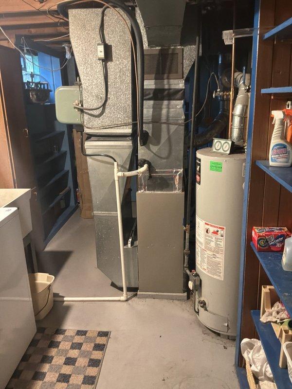 Conducted site evaluation for air conditioning replacement estimate on 20+ year old unit currently located in backyard. Existing AC system is operational but nearing end of service life. Assessed basement mechanical room containing natural gas furnace and water heater, documented existing ductwork configuration, electrical service panel, and utility infrastructure to determine compatibility requirements for new cooling equipment installation.