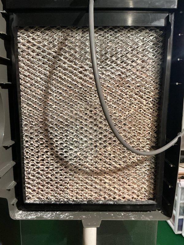 Completed comprehensive 5-year ComfortGuard maintenance visit on HVAC system. Performed thorough inspection of evaporator coil assembly, which showed moderate dust and particulate accumulation on the honeycomb mesh surface with visible discoloration throughout. Inspected drainage line and refrigerant conduit for proper operation and positioning. Removed and evaluated pleated air filter, which displayed dust buildup consistent with normal operational use. Filter frame and internal accordion-style pleated media were examined for structural integrity and airflow restriction. Verified all frame fasteners, rivets, and housing components were secure and properly sealed. System components were documented photographically for maintenance records.