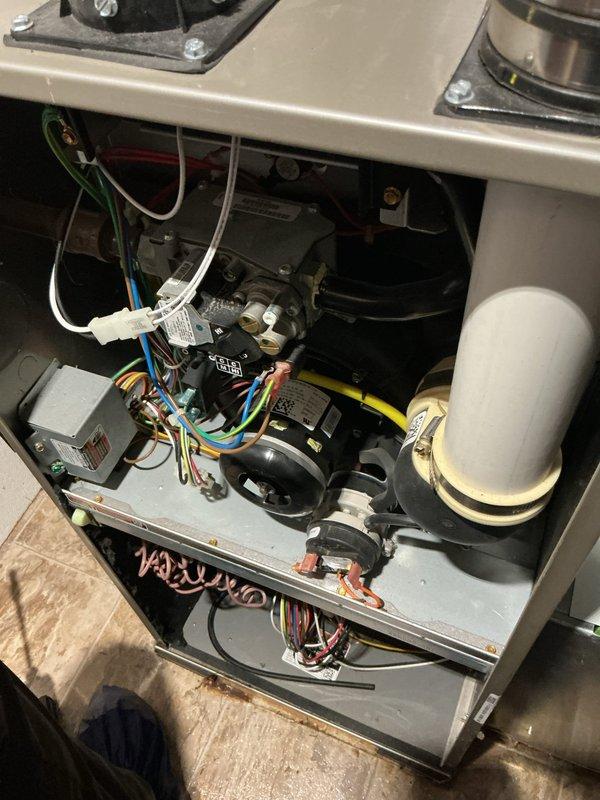 Responded to emergency service call for reported gas odor from 7-year-old furnace in basement, which had been shut down for safety. Upon arrival, performed comprehensive safety inspection of gas furnace and all connections. Inspected blower motor assembly, gas valve, electrical connections, and all internal components for potential gas leaks or failures. Examined combustion chamber, heat exchanger, and burner assembly for cracks or deterioration that could cause gas odor. Tested all gas line connections, fittings, and the main gas valve using leak detection methods. Verified proper venting through PVC intake and exhaust pipes. Cleaned debris from interior cabinet and checked all wiring harnesses and electrical connections for damage. Inspected condensate drain system and associated plumbing connections. Unit required further evaluation to determine source of gas odor before safe return to operation.