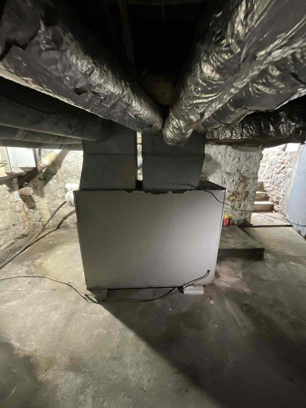 Conducted estimate for furnace replacement in basement location. Current oil-fired heating system is operational but over 40 years old and nearing end of service life. Customer requested conversion from oil to natural gas fuel source. Assessed existing ductwork configuration, including flexible metallic ducts with insulation extending from current air handler unit. Evaluated basement space conditions, concrete floor placement, and electrical requirements for new gas furnace installation. Documented existing HVAC equipment layout and ductwork connections to provide accurate replacement specifications and conversion requirements from oil to natural gas heating system.