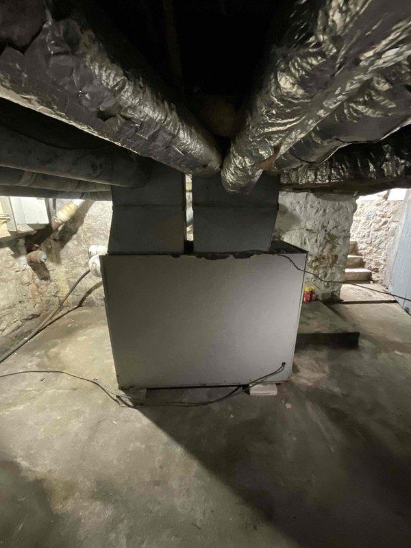 Conducted estimate for furnace replacement in basement location. Current oil-fired heating system is operational but over 40 years old and nearing end of service life. Customer requested conversion from oil to natural gas fuel source. Assessed existing ductwork configuration, including flexible metallic ducts with insulation extending from current air handler unit. Evaluated basement space conditions, concrete floor placement, and electrical requirements for new gas furnace installation. Documented existing HVAC equipment layout and ductwork connections to provide accurate replacement specifications and conversion requirements from oil to natural gas heating system.