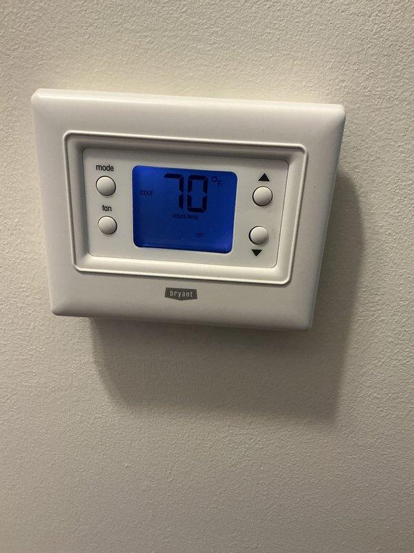 Completed annual cooling maintenance on Bryant residential air conditioning system. Performed comprehensive inspection of indoor and outdoor components, including thermostat operation verification, condenser unit examination, and filter replacement as part of routine preventive maintenance service. System operating properly with thermostat displaying 70°F in cooling mode and outdoor condenser unit showing normal wear consistent with regular operation.