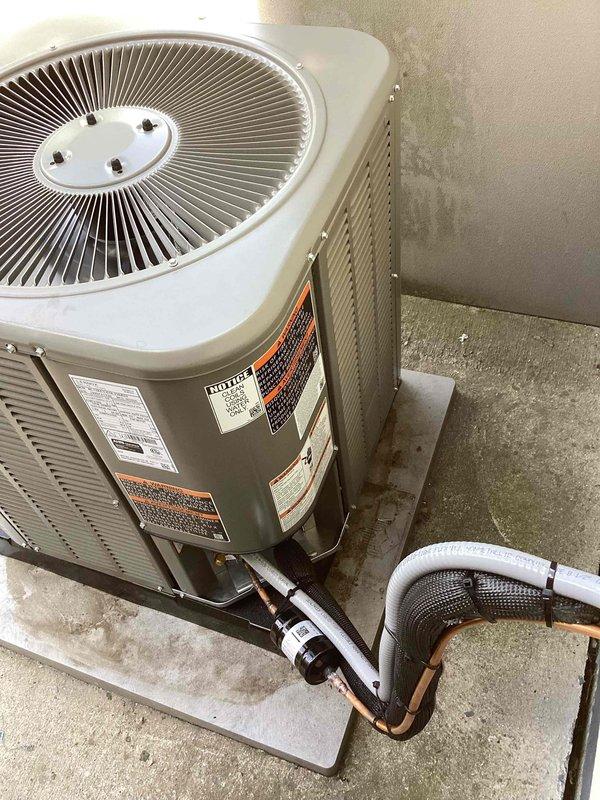 Completed full HVAC system installation including new furnace, air conditioning condenser unit, and evaporator coil. Positioned outdoor condenser unit on concrete pad with proper clearance from building exterior, installed insulated refrigerant line set with copper piping, and connected electrical conduit to house. All equipment properly mounted, refrigerant lines secured with foam insulation, and system tested for operational functionality upon completion.