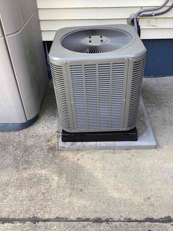 Completed full HVAC system installation including new furnace, air conditioning condenser unit, and evaporator coil. Positioned outdoor condenser unit on concrete pad with proper clearance from building exterior, installed insulated refrigerant line set with copper piping, and connected electrical conduit to house. All equipment properly mounted, refrigerant lines secured with foam insulation, and system tested for operational functionality upon completion.