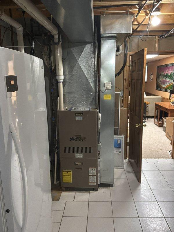 Conducted full system estimate for replacement of existing 16-year-old heating and cooling equipment in residential basement installation. Evaluated current furnace and ductwork configuration, documented existing thermostat operation displaying 74°F current temperature, and assessed mechanical room layout including water heater proximity and available space for new equipment installation. Customer seeking replacement within the next couple weeks; provided comprehensive estimate for complete HVAC system replacement including furnace, air conditioning unit, and any necessary ductwork modifications.